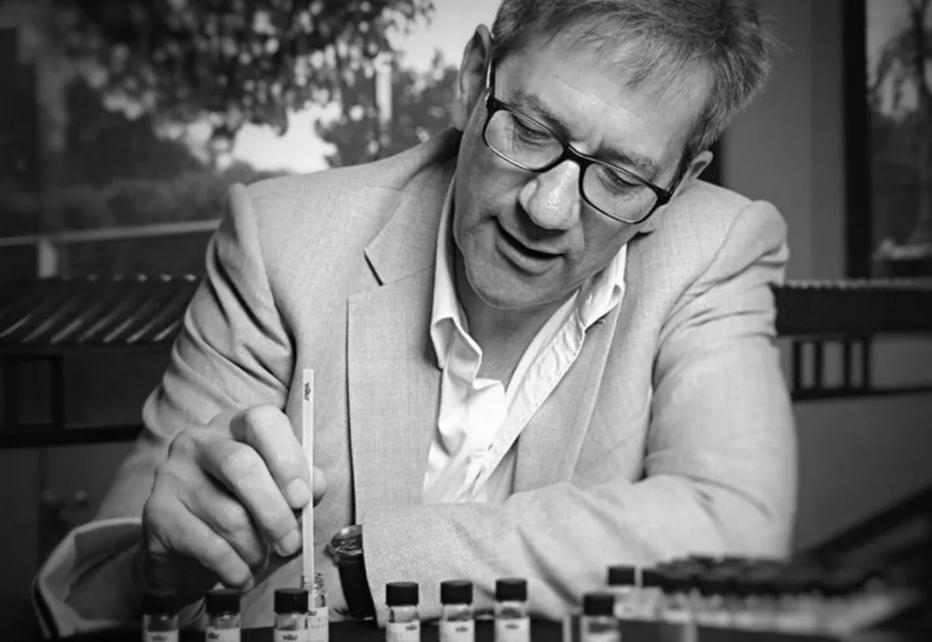 John Stephen dipping a fragrance blotter strip among sample vials