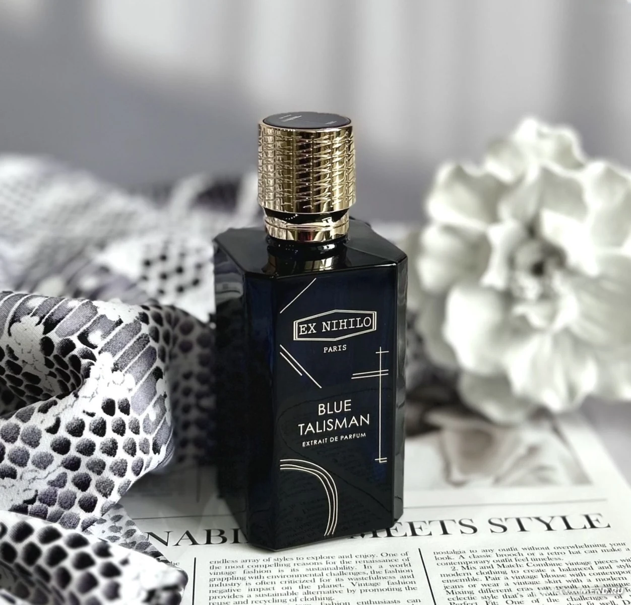 Blue Talisman Extrait bottle with patterned textile and flower