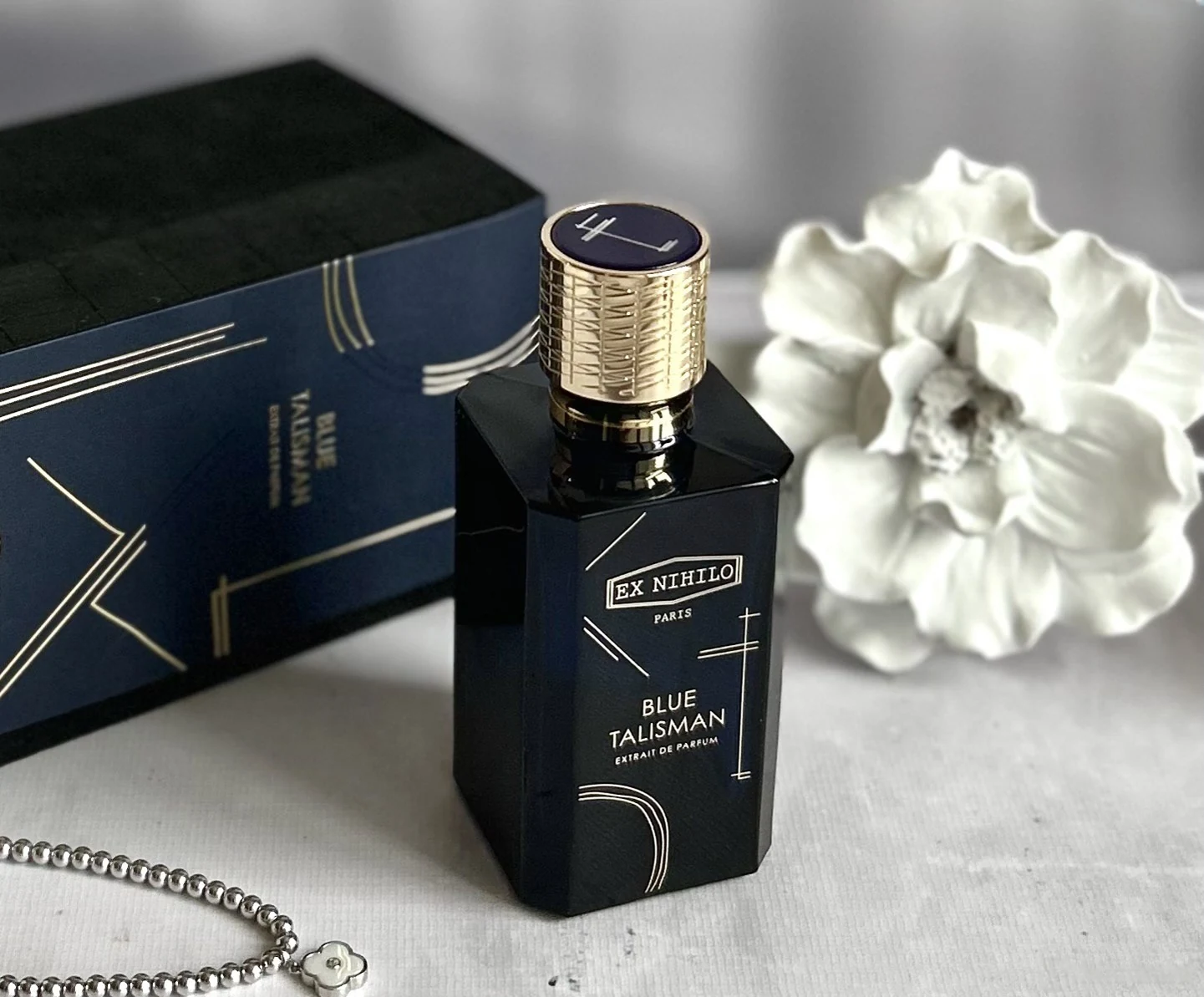 Blue Talisman Extrait bottle and box in soft monochrome setting